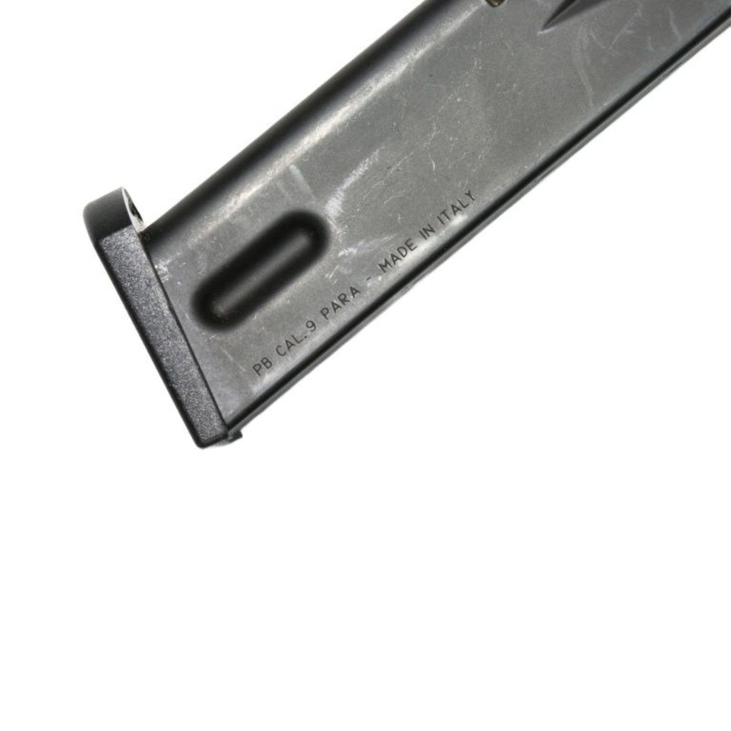 Side view of a black steel Beretta M92S 9mm 15 round magazine with witness holes for ammunition count.